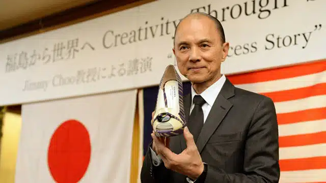 Malaysian designer Jimmy Choo holds his one-off set of shoes using materials of Japan's Fukushima area during his lecture "Creativity Thugh Skills" in Fukushima city on April 18, 2014. World famous designer Jimmy Choo unveiled six pairs of shoes using materials and techniques native to Japan's Fukushima area, in a bid to boost the profile of artisans there struggling in the aftermath of the tsunami-sparked nuclear disaster.      AFP PHOTO / TOSHIFUMI KITAMURA